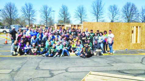 Student volunteers pose in front of the constructed frames at the Building Walls Event