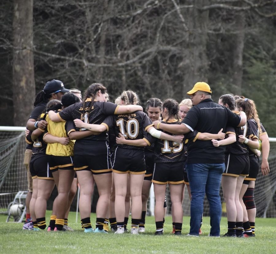Women’s Rugby embrace each other at a tournament.