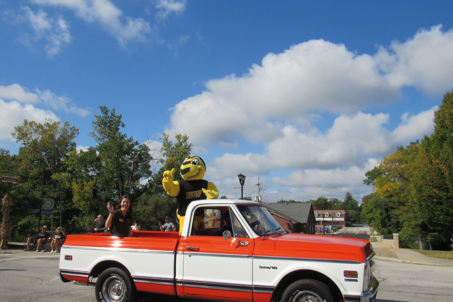 Sarah Kittleberger, senior public health student, rides with the mascot during the homecoming parade. 
