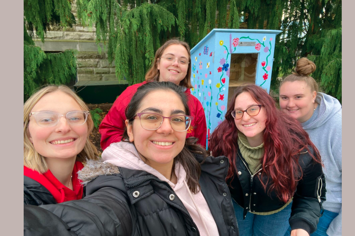 Book Jackets members stand by the Little Free Library, built by BW Book Jackers and Circle K International, by the rose garden between Marting and Dietsch Halls. 