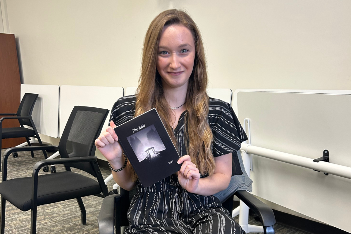 Assistant editor Hope Mlecik holds a copy of the 2025 edition of The Mill journal.